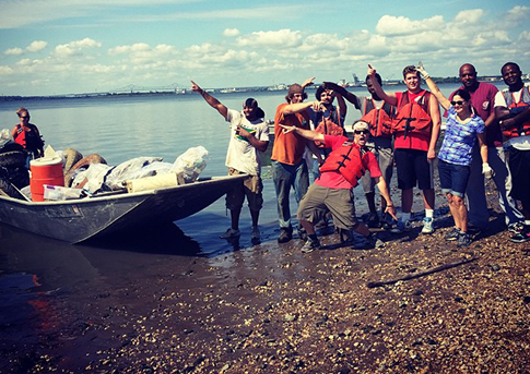 A crew of volunteers celebrates after hauling an impressive load of trash from the Delaware River. Credit: Living Lands and Waters.