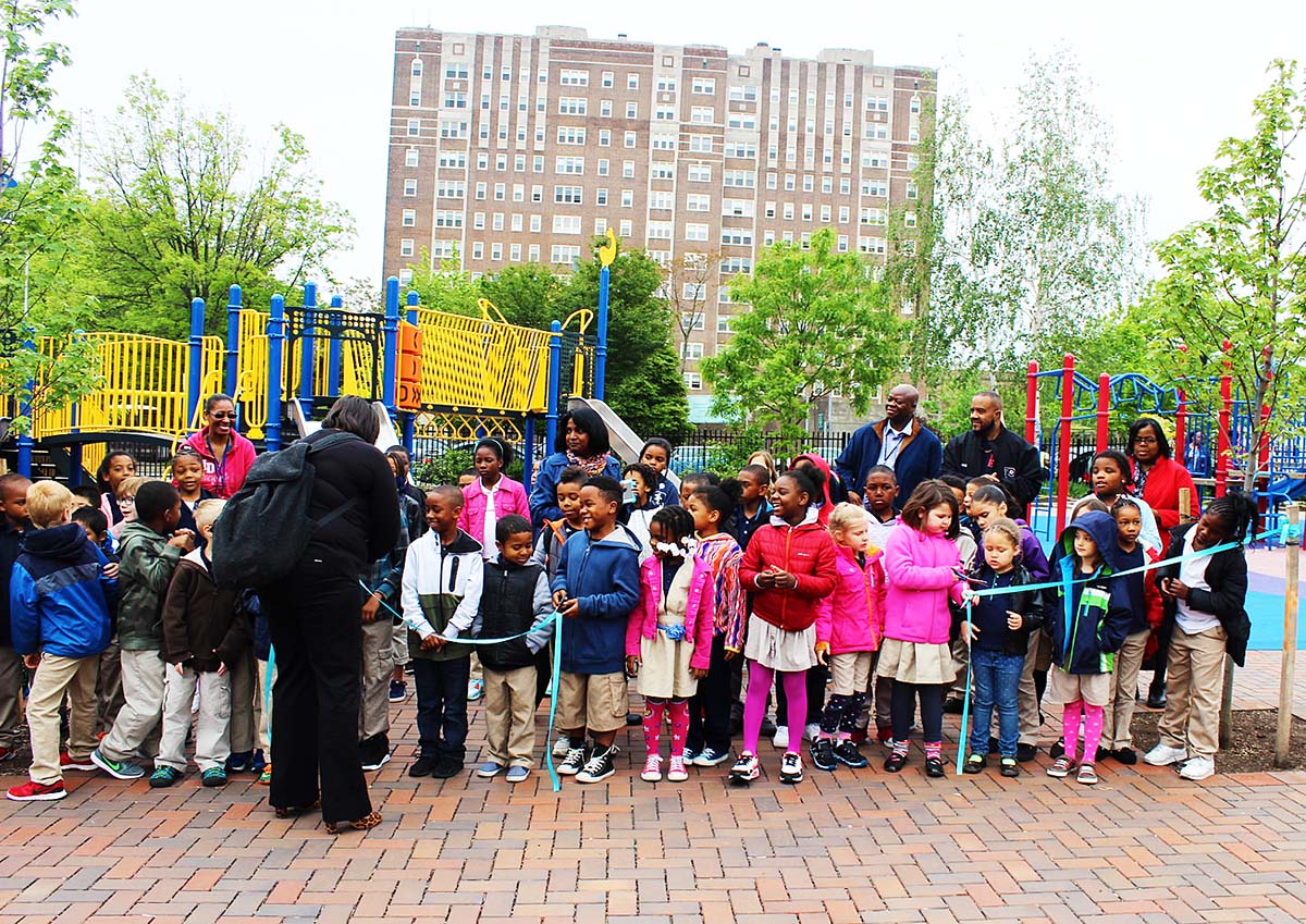 Students and parents cut the ribbon at Lea Elementary in 2016 to celebrate the completion of a schoolyard featuring three rain gardens, nearly two dozen new trees and porous paving and play surfaces. Funded largely through a $242,000 SMIP grant from PWD, the project won the Public Project Award at the 2016 Excellence in GSI Awards ceremony. Credit: PWD 